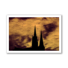 Silhouette of a cathedral against a dramatic sky with warm colors