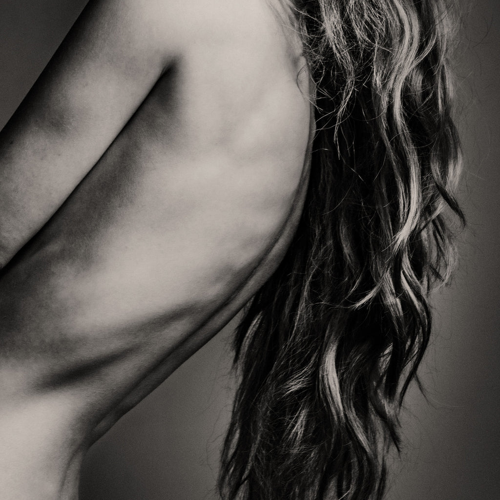 Black and white photo of a person with wavy hair and a blurred background