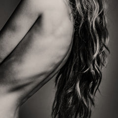 Black and white photo of a person with wavy hair and a blurred background