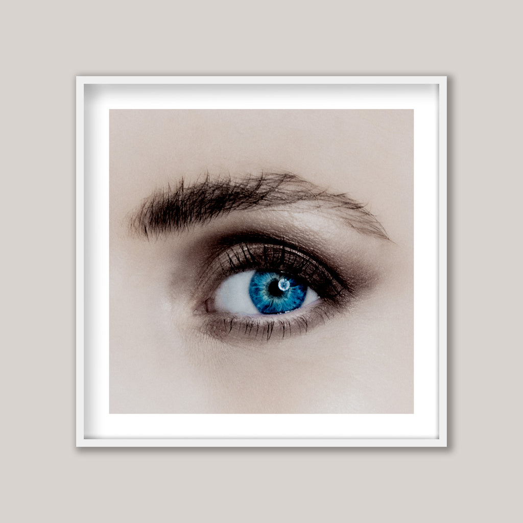 Framed artwork of a close-up of a blue eye on a beige background